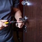 Locksmith replacing door lock to new after losing keys. Robbery protection, safety improvement. Repairman or workman changing or repair door lock.