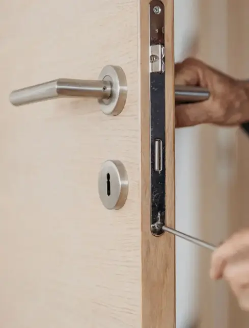 zoom sur les mains d'un serrurier lille qui change une serrure avec un tournevis